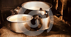 Metallic tea kettles on top of a clay made stoves
