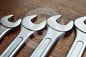 Metallic wrenches on a wooden background photo