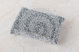 Metallized fiber foam sponge for dishes and housework. New silver foam sponge for dishwashing on a kithen table. Purity and