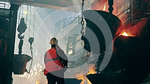 Metallurgical factory interior. Metallurgical plant unit with a steel worker in protection wear