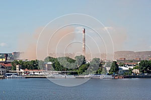 Metallurgical plant near a beautiful lake. Emission of nitrogen oxide into the atmosphere. Pollution of the environment.