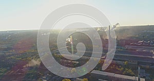 Metallurgical plant at sunrise top view. Industrial zone aerial view. Smoke from the chimney of a factory at sunset