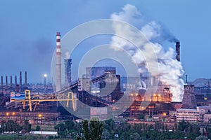 Metallurgical plant with white smoke at night. Steel factory with smokestacks . Steelworks, iron works. Heavy industry