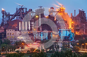 Metallurgical plant with white smoke at night. Steel factory with smokestacks . Steelworks, iron works. Heavy industry