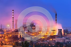 Metallurgical plant with white smoke at night. Steel factory with smokestacks . Steelworks, iron works. Heavy industry