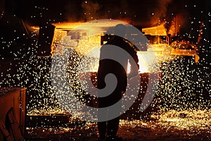 Metallurgist steelmaker takes a sample of liquid metal from a ladle.