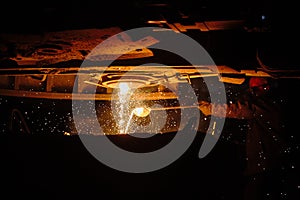 Metallurgist steelmaker takes a sample of liquid metal from a ladle.