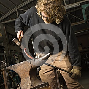 Metalsmith shaping metal.