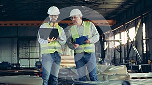 Metalware factory unit with male technicians inspecting it