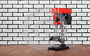 Metalwork tool - Red new drill press white brick wall background