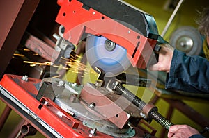 Metalworker cutting metal detail rotary saw