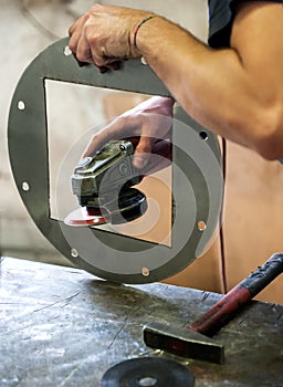 Metalworker sanding a metal component