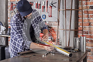 Metalworker taking measurements on a metal pipe photo