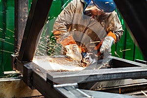 Metalworker working with angle grinder