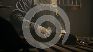 Metalworker in the workshop makes measurements with ruler, calculations and puts serifs with chalk. Locksmith in special clothes