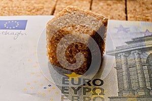 A metaphor for the cost of sweetness, as a Euro banknote covers a pile of brown sugar