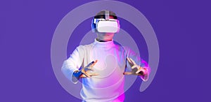 Metaverse asian man in white long sleeve t-shirt wear vr headset watching touching on purple color background