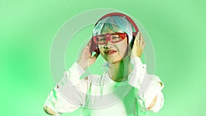 Metaverse music concept, young asian woman wearing white glasses ang red headphone listen to music and dancing