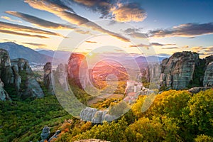 Meteora, Greece. Panoramic landscape of Meteora, Greece at romantic sundown time with real sun and sunset sky. Meteora -
