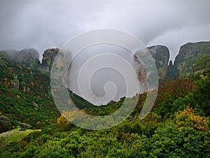 Meteora, Greece, winter dramatic landscape with heavy clouds and foggy mountains. Vibrant colorful nature