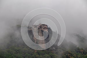 Meteora - Panoramic view on foggy day of Holy Orthodox Monastery of Rousanou (St. Barbara), Kalambaka, Meteora, Greece.