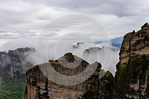Meteora - Panoramic view of unique rock formations near Holy Monastery of Varlaam on cloudy foggy day in Kalambaka