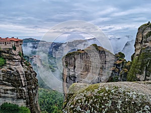 Meteora - Panoramic view of unique rock formations near Holy Monastery of Varlaam on cloudy foggy day in Kalambaka