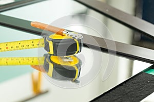 A ruler and a glass cutter, They lie on the mirror, The glass industry and the glazier tools