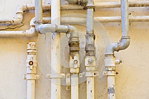 Methane gas and water metal pipe against a plaster wall of a res