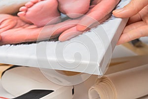 The method of bending the canvas on the corner of the stretcher when stretched. The hand shows a photograph printed on canvas and