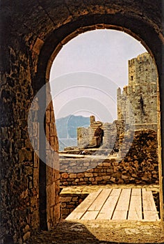Methoni Castle viewed through a medieval archway.