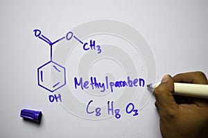 Methylparaben C8,H8,O3 molecule written on the white board. Structural chemical formula. Education concept photo