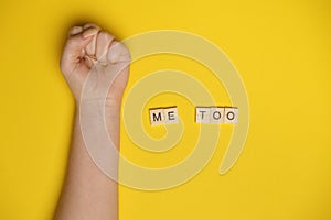 MeToo on wooden alphabet, used for concept of sexual harrassment. Woman fist as protest in shot