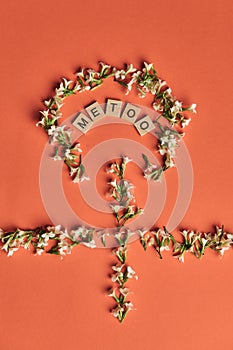 MeToo on wooden alphabet, used for concept of sexual harrassment. Woman gender symbol stylized with flowers