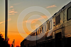 Metra train travels into the sunset at the end of a late winter day.