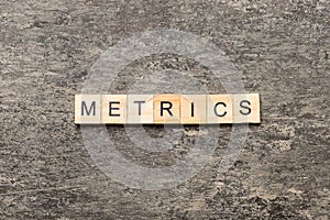 METRICS word written on wood block. METRICS text on cement table for your desing, concept
