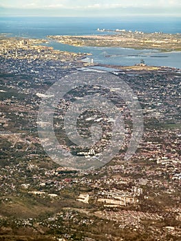 The Metro area of Cebu City and Mactan Island as seen from an airplane. Urban landscape, coastal area, and surrounding mountains