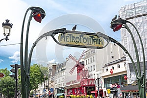 Metro sign and Moulin Rouge cabaret in Paris, France