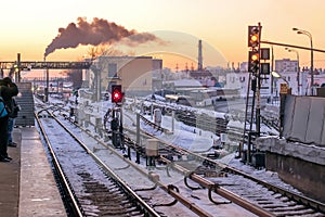 Metro station on the background of urban landscape in winter with snow and rails with traffic lights