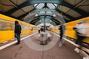 Metro station on eberswalder street, old metal station construction. Two trains just arriving at the station in motion blur.