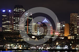 Metropolitan city with wharf and skyline by night