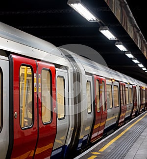 Train on the platform at Euston Square Underground Station, London UK, showing reflection of train on ceiling above.