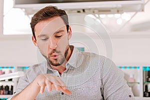 Metrosexual blowing at his nails while getting manicure photo