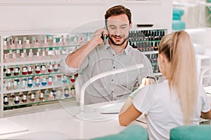 Metrosexual businessman getting manicure in beauty salon