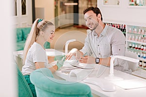 Metrosexual man looking at his lovely blonde-haired nail master