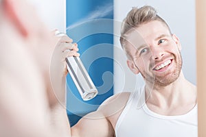 Metrosexual man using hair spray photo
