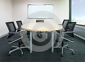 The metting room have wood desk and black chairs. Office meetting room.