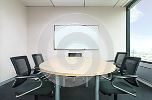 The metting room have wood desk and black chairs. Office meetting room.