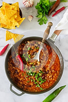 Mexican and American food Chili con carne served with nachos, pepper and herbs. photo