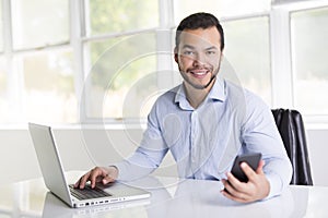 Mexican attractive businessman on his 30s working at modern home office with computer laptop